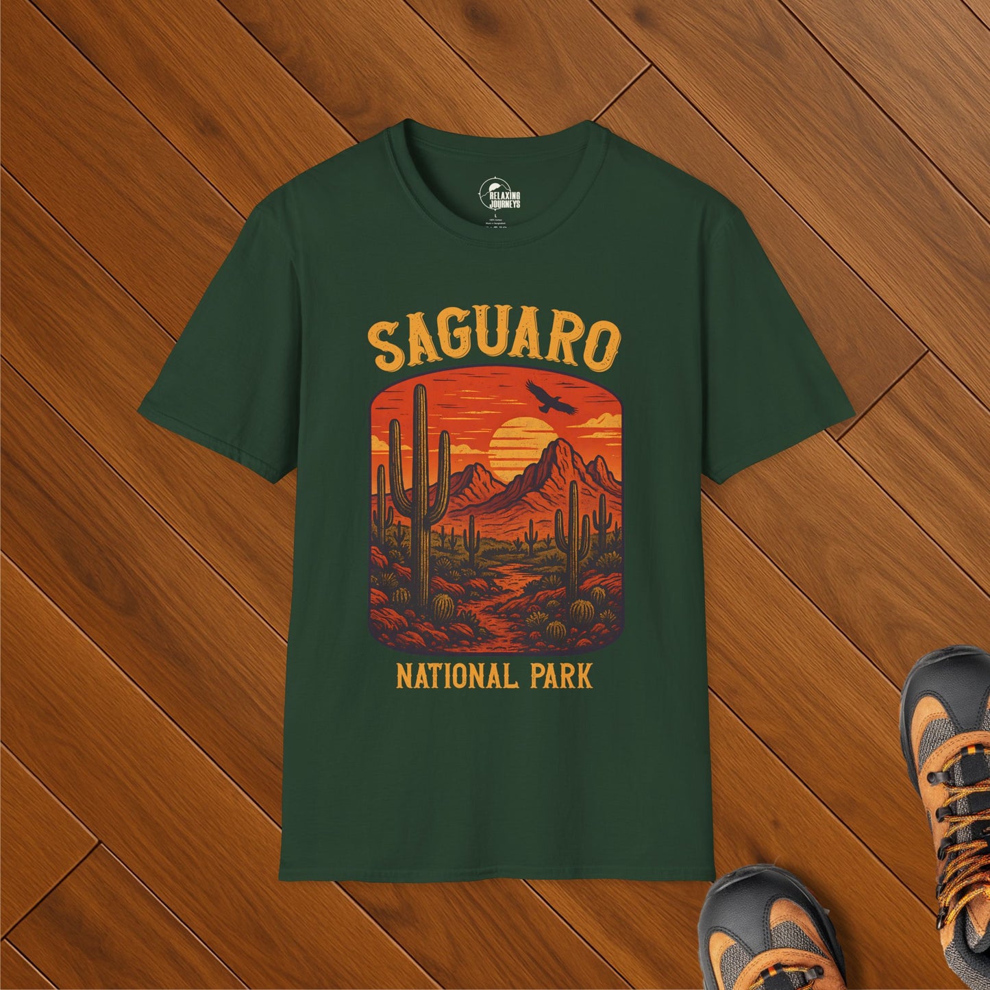 Dark green t-shirt with vintage sunset illustration of Saguaro National Park featuring tall saguaro cactuses, desert mountains, and a flying bird
