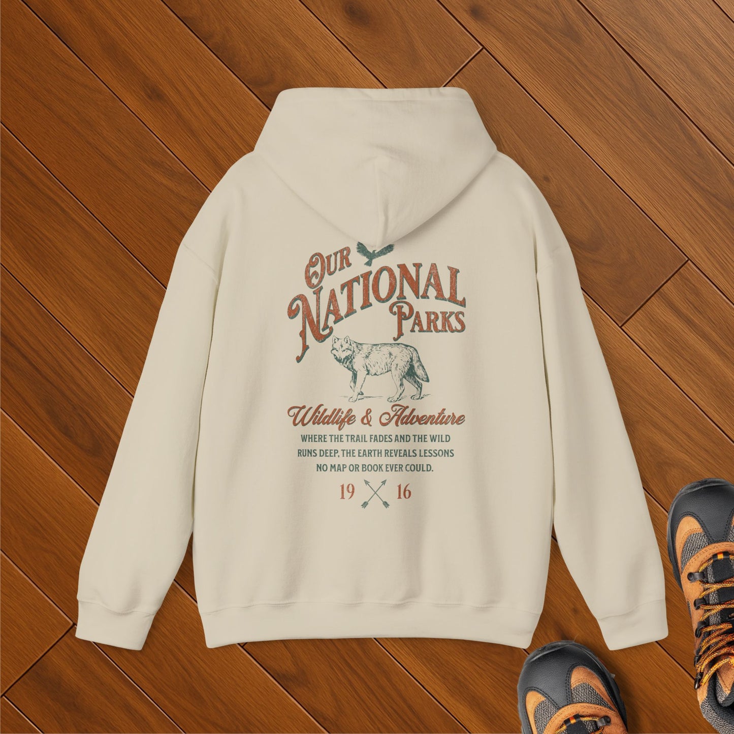 Natural-colored hoodie featuring a vintage-style illustration of a wolf beneath the words "Our National Parks." Includes an inspirational message about wildlife, adventure, and nature discovery.