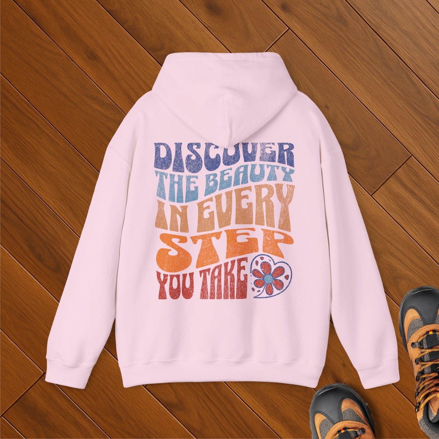 Pink hoodie with colorful retro typography reading “Discover the beauty in every step you take” – positive mental health hiker gift