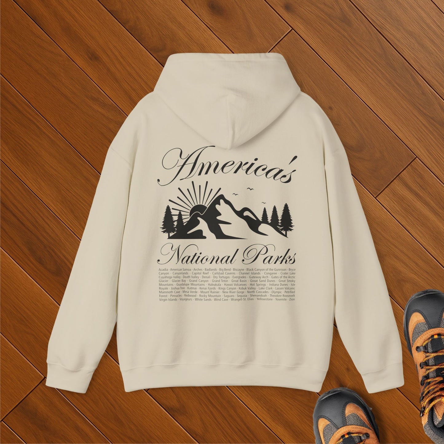 Beige hoodie with “America’s National Parks” text and mountain design on back, featuring all 63 U.S. national parks listed as a checklist – eco-conscious gift