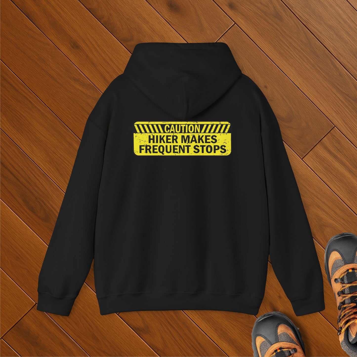 A black hoodie with Caution: Hiker Makes Frequent Stops Hoodie. This Funny Hiking Sweatshirt shows off your trail humor. With sizes to 5X, this eco-friendly, outdoorsy hooded sweatshirt is perfect for national park lovers.