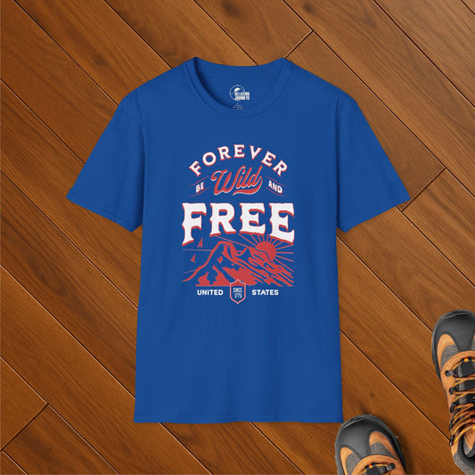 Royal blue t-shirt with red, white, and blue “Forever Wild and Free” text and mountain design, styled on wood floor with hiking boots