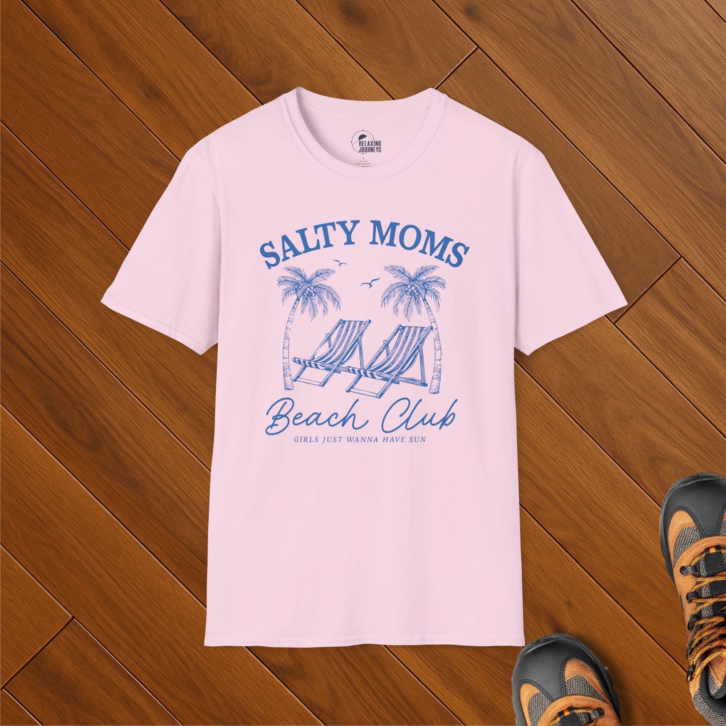 Light pink t-shirt with a blue vintage graphic that says "Salty Moms Beach Club" featuring palm trees, beach chairs, and the phrase "Girls Just Wanna Have Sun" in a beachy vacation design.