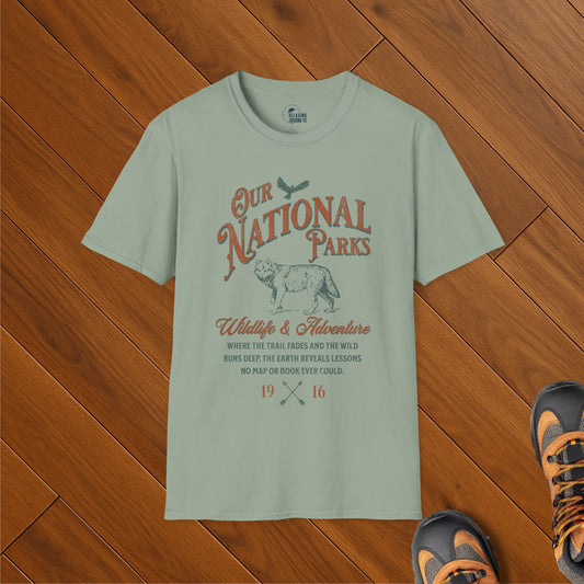 Sage green t-shirt with vintage-style “Our National Parks” design featuring a wolf illustration, eagle, and conservation message