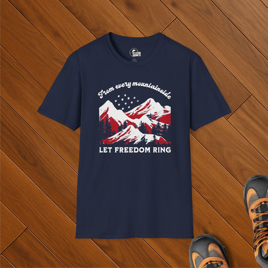 Navy blue t-shirt with red, white, and blue mountain design and the text “From every mountainside, Let Freedom Ring,” styled on wood floor with hiking boots