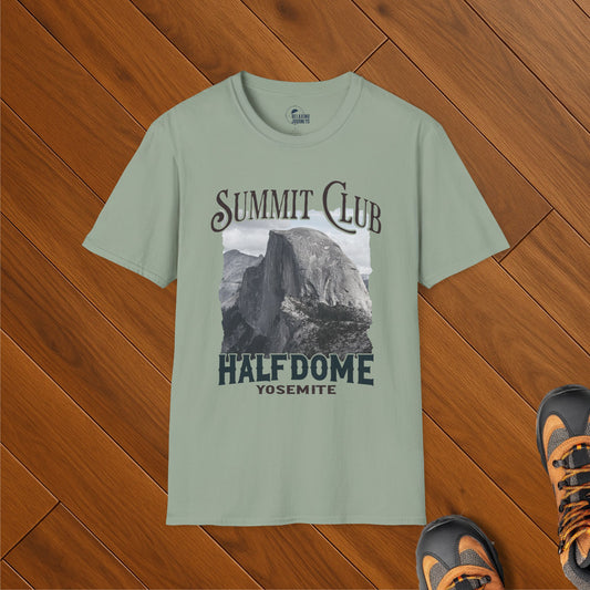 Sage green t-shirt featuring Half Dome Yosemite Summit Club design, folded on wood floor next to hiking boots