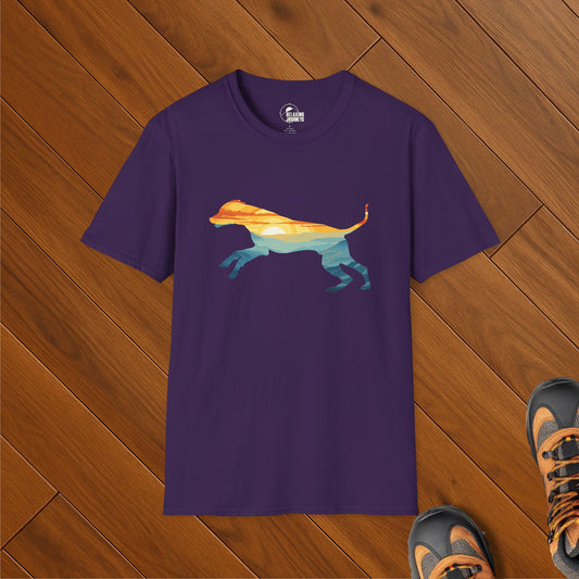 Purple t-shirt featuring a colorful landscape silhouette of a running dog, styled on wood floor with hiking boots