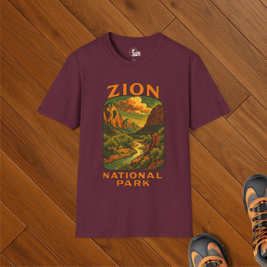 Maroon t-shirt featuring a vintage-style illustration of Zion National Park with sandstone cliffs, a winding river, and golden sunset sky